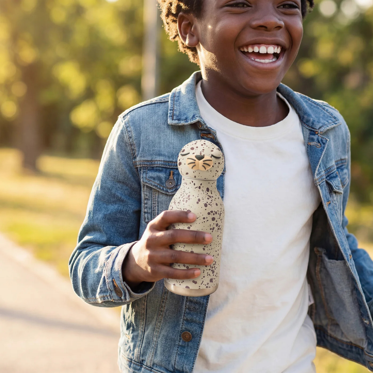 Child carrying Asobu Animal Bestie Bottle in Seal design with removable silicone character head during an everyday adventure in Whistler