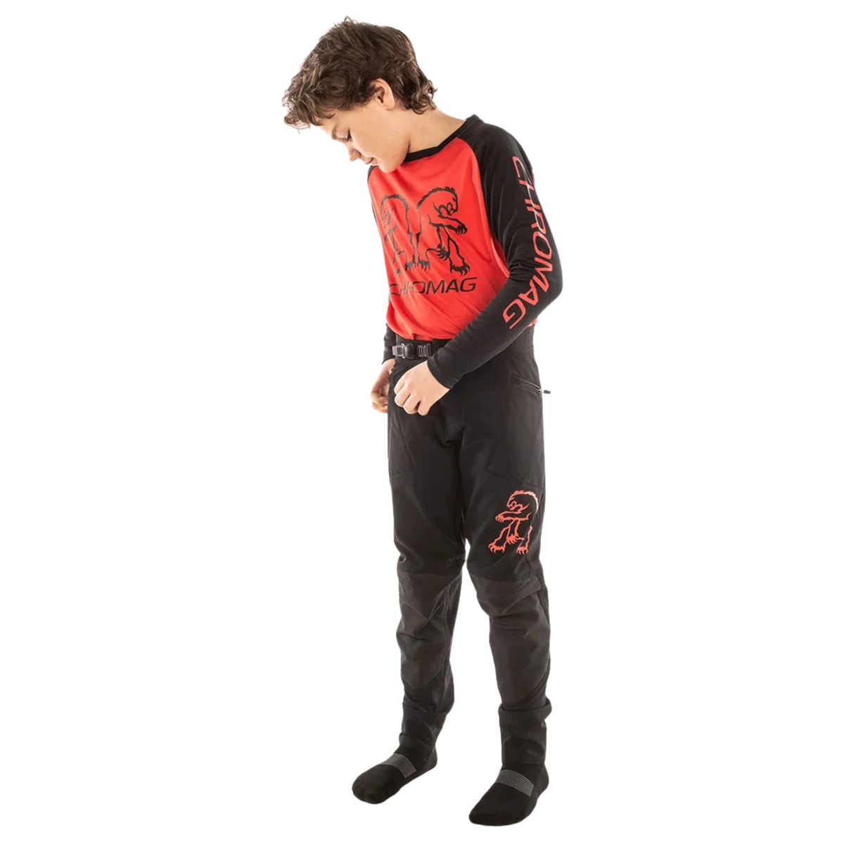 Young rider wearing Chromag Kids Feint Bike Pants with reinforced knees and 4-way stretch fabric while riding Whistler Bike Park