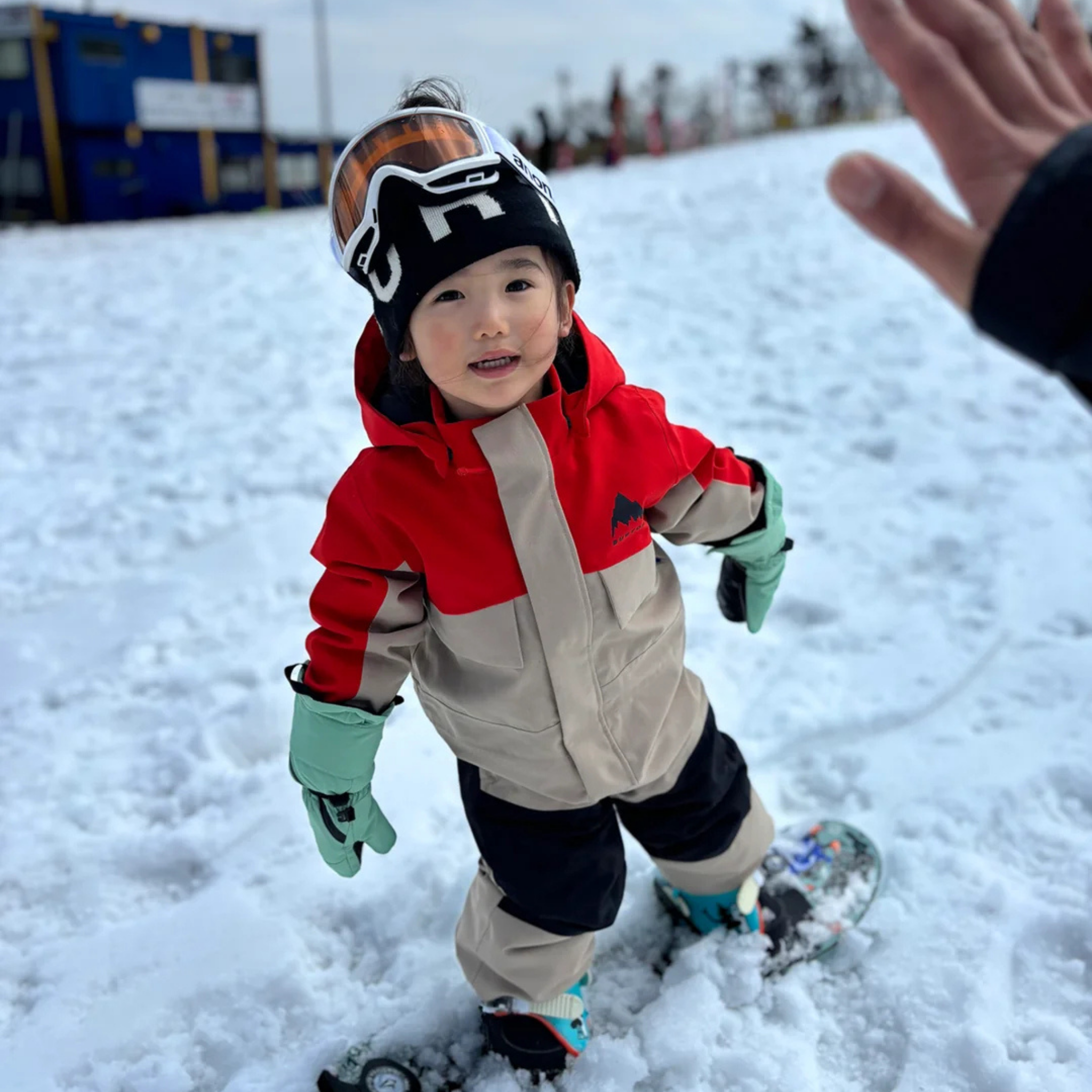 Young rider wearing Burton One-Piece Snowsuit in Flame Scarlet / Summit Taupe design with 15K waterproofing and 100g insulation in Whistler