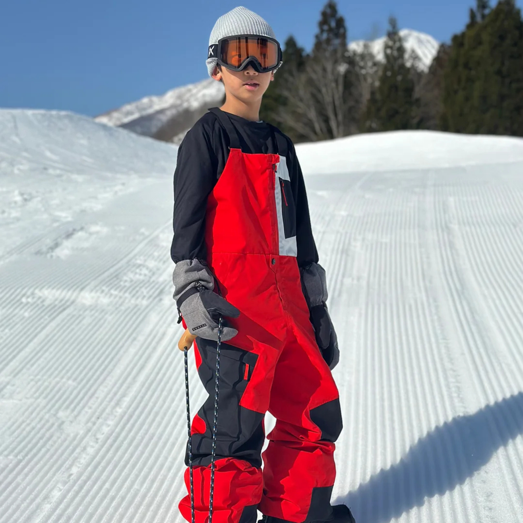 Young snowboarder wearing Burton Powline GORE-TEX Bib Pants with 60g insulation while riding in Whistler