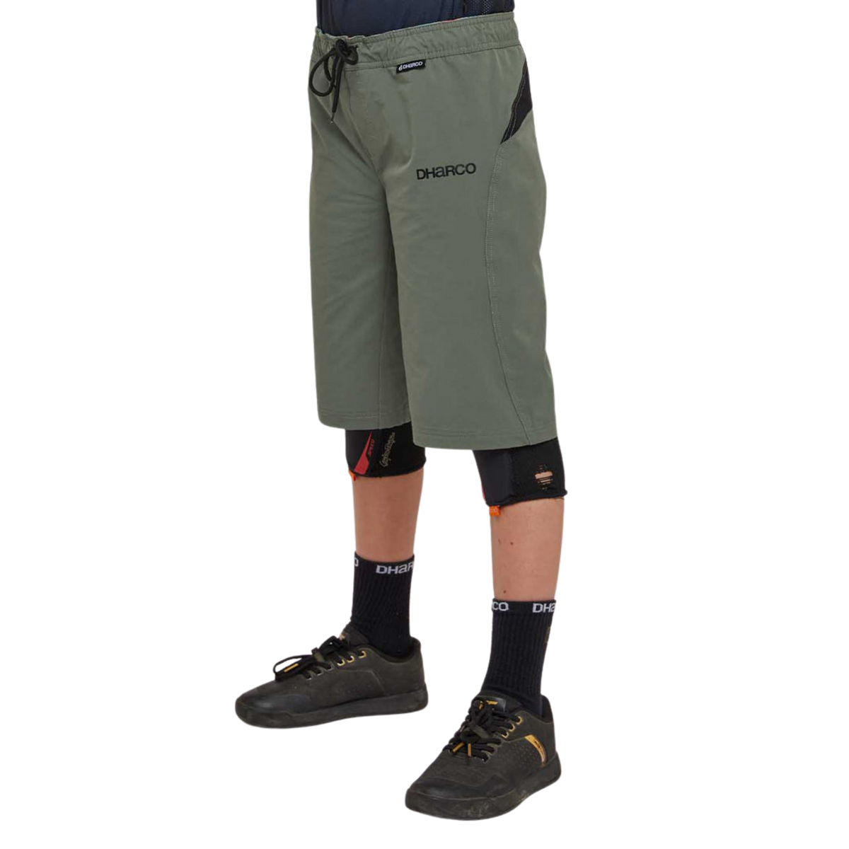 Side view of DHaRCO Youth Gravity Shorts in Gorilla Green with longer MTB fit, 4-way stretch fabric and zippered pocket