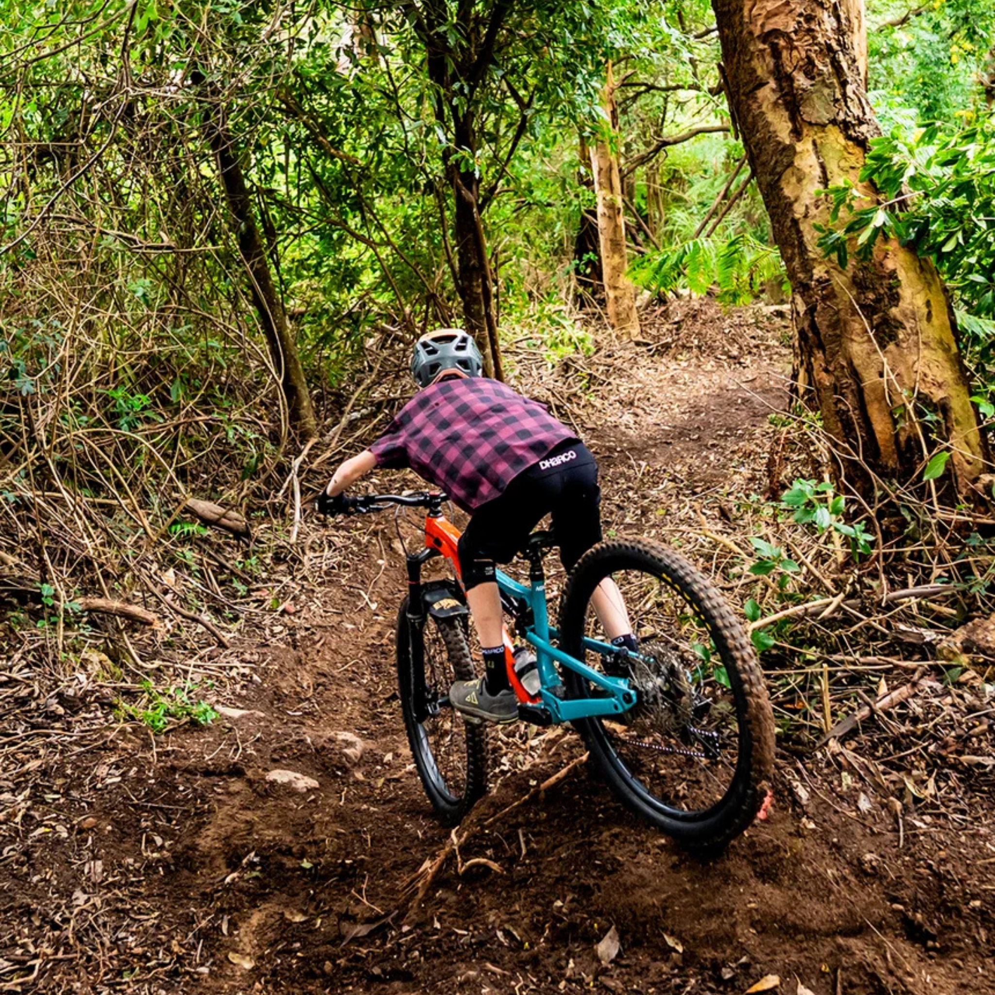 Young mountain biker wearing DHaRCO Youth Gravity Shorts with knee pads, 4-way stretch fabric and water-resistant finish in Whistler