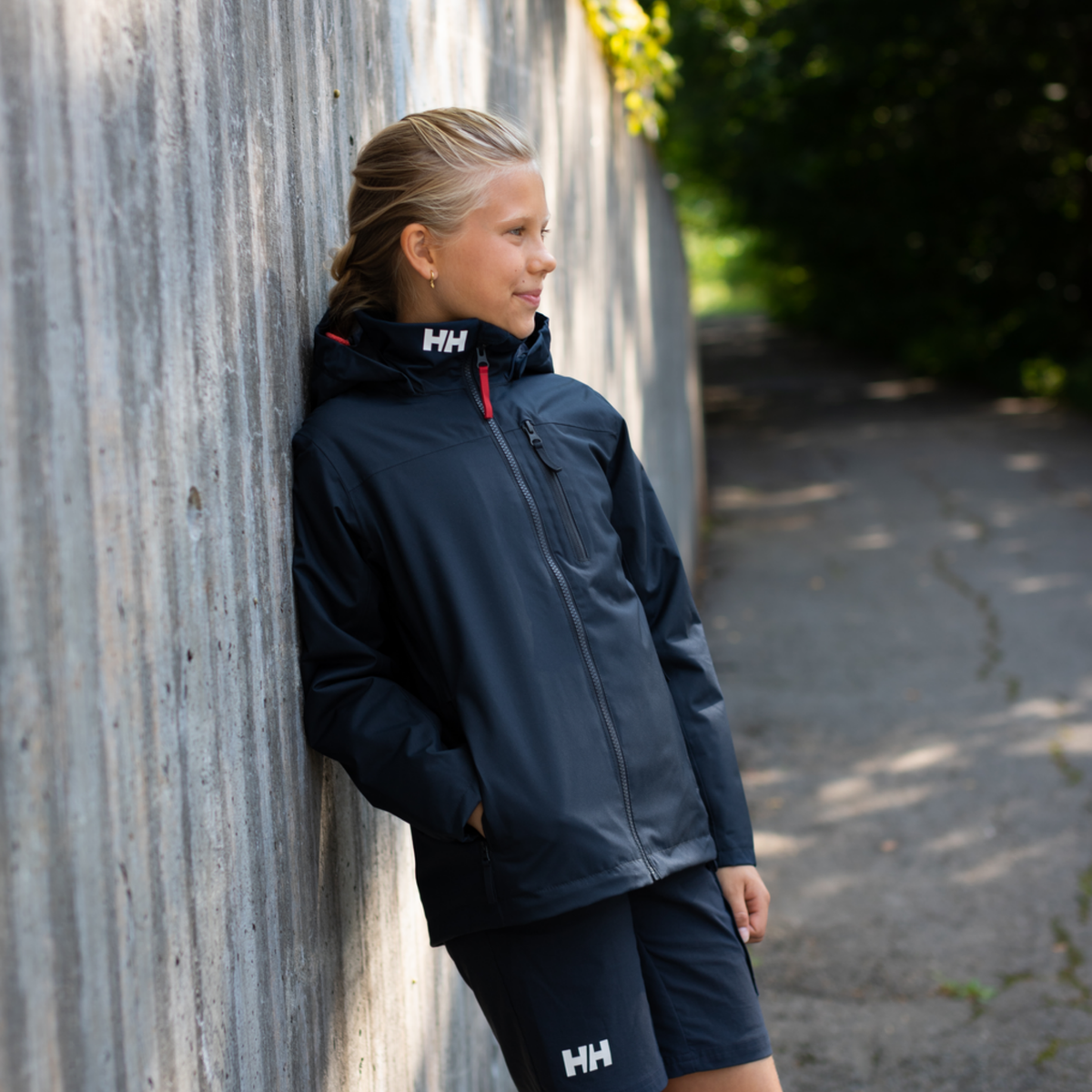 Child wearing Helly Hansen Jr Crew Midlayer 2.0 Unisex Jacket in Navy with waterproof protection and fleece lining in Whistler