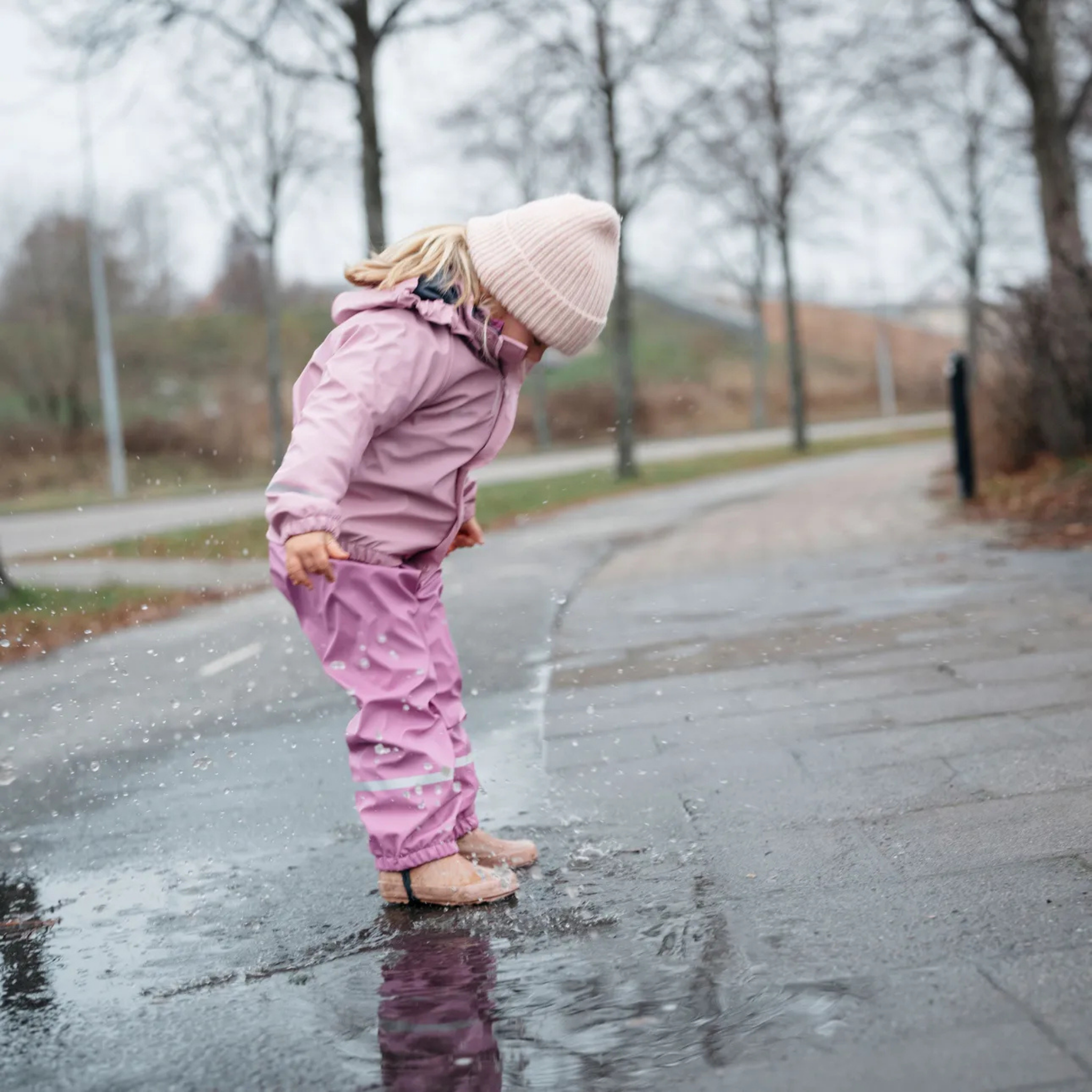 Child wearing Helly Hansen Kids Bergen 2.0 Rain Set with waterproof jacket and bib overalls on a rainy day in Whistler