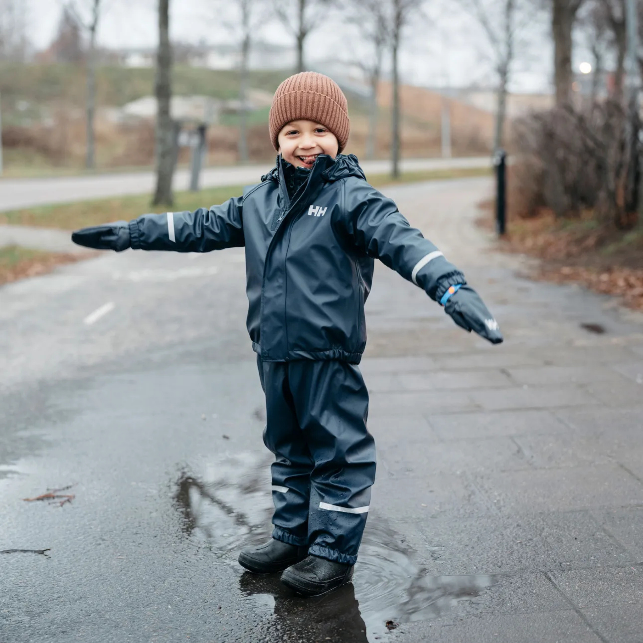 Child wearing Helly Hansen Kids Bergen Fleece-Lined Rain Set 2.0 with waterproof HELOX+ protection and warm fleece lining in Whistler