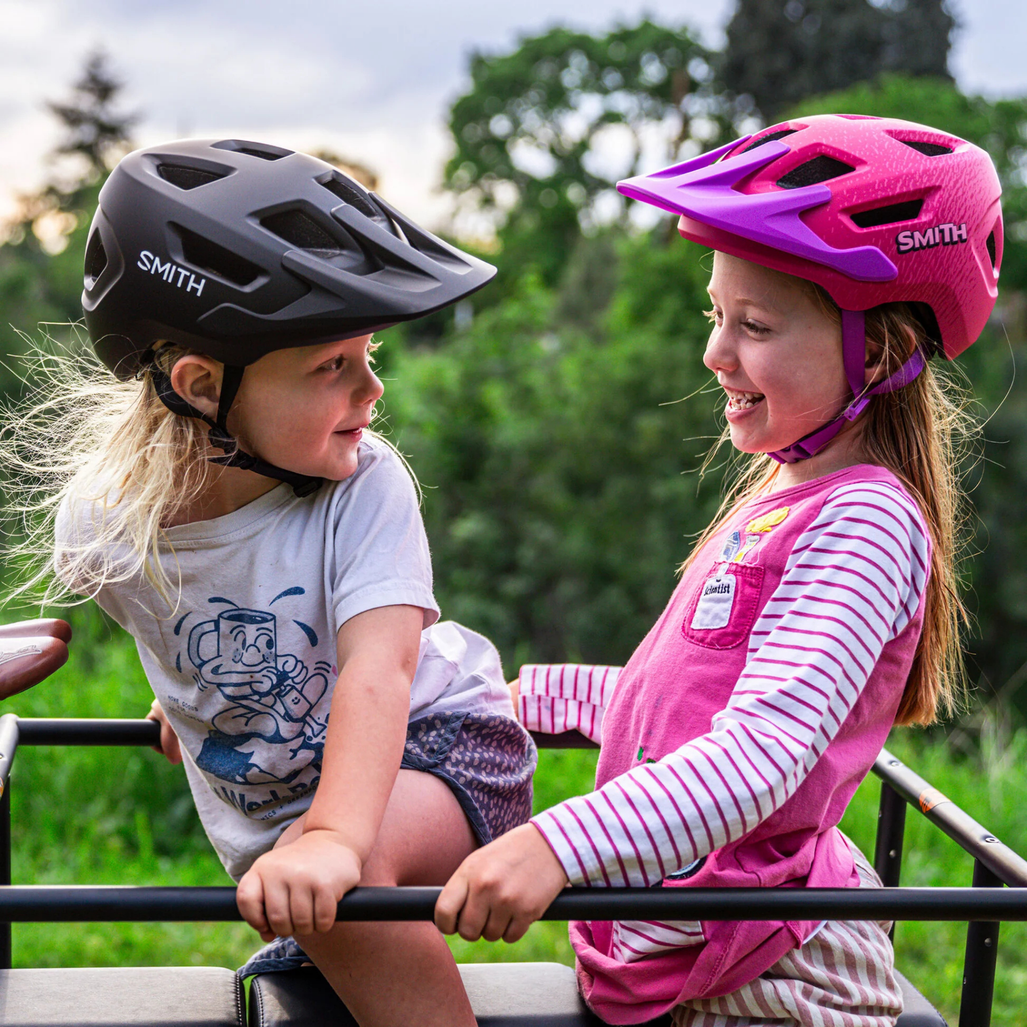 Young mountain biker wearing the Smith Sidekick Jr MIPS helmet in Matte Black and Lollipop Pink while riding Whistler trails