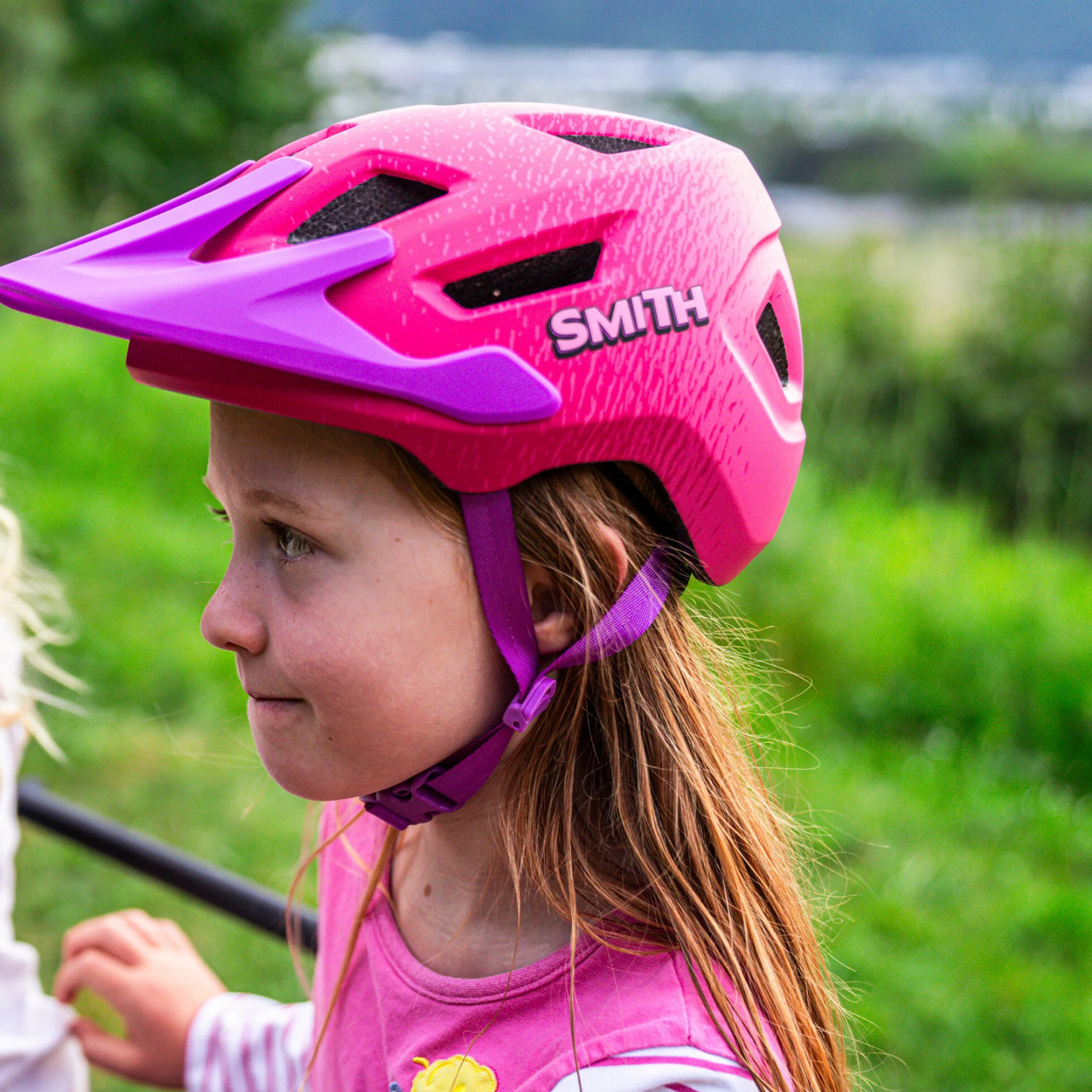 Young mountain biker wearing the Smith Sidekick Jr MIPS helmet in Matte Lollipop Pink riding Whistler trails