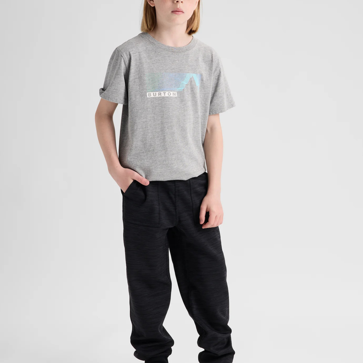 Child wearing Burton Kids Oak Fleece Pants in Black Heather with recycled brushback fleece, handwarmer pockets and ribbed cuffs