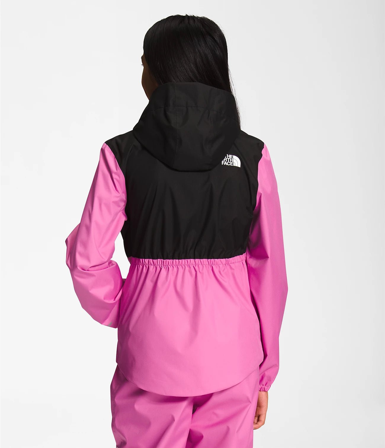 Back view of a Smiling girl wearing Super Pink The North Face Girls' Warm Storm Jacket - Mountain Kids Outfitters: Stylish and Weather-Ready Outerwear