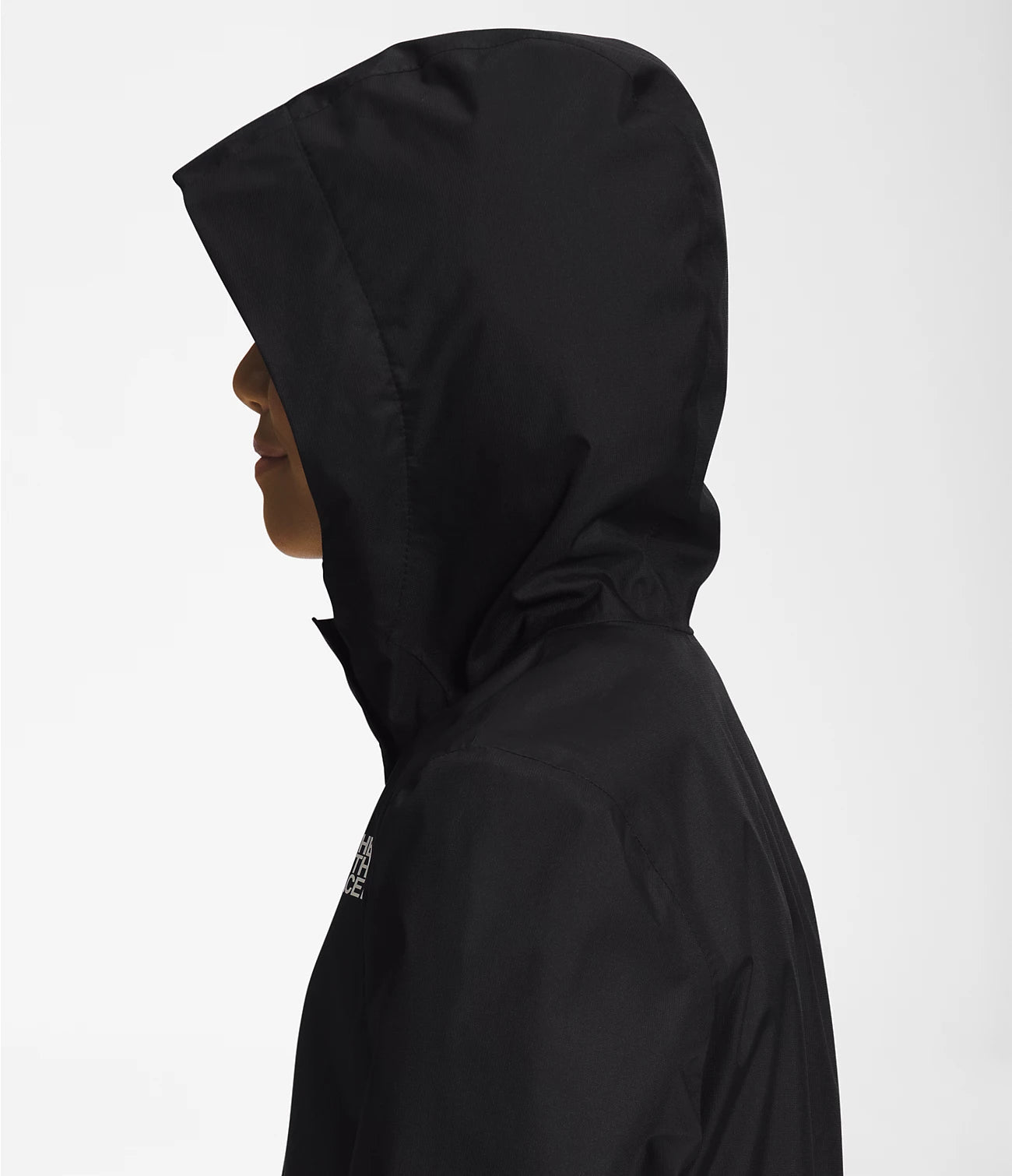 Side view of a girl wearing Black The North Face Girls' Warm Storm Jacket with Hoodie on - Mountain Kids Outfitters: Stylish and Weather-Ready Outerwear