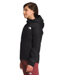 Side View of a Smiling girl wearing Black The North Face Girls' Warm Storm Jacket - Mountain Kids Outfitters: Stylish and Weather-Ready Outerwear